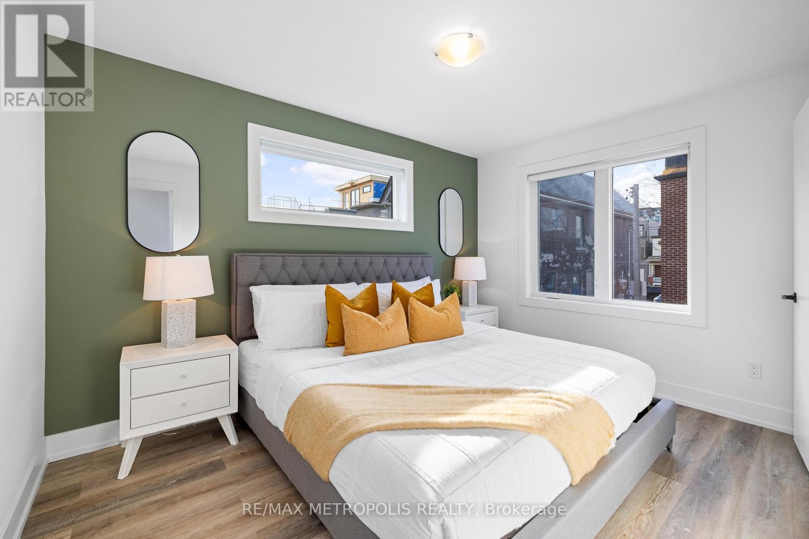 A bedroom with a white bed and a green wall.