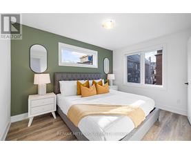 A bedroom with a white bed and a green wall.