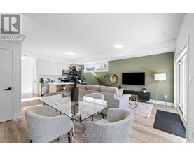 A modern dining room with a glass table and grey chairs.