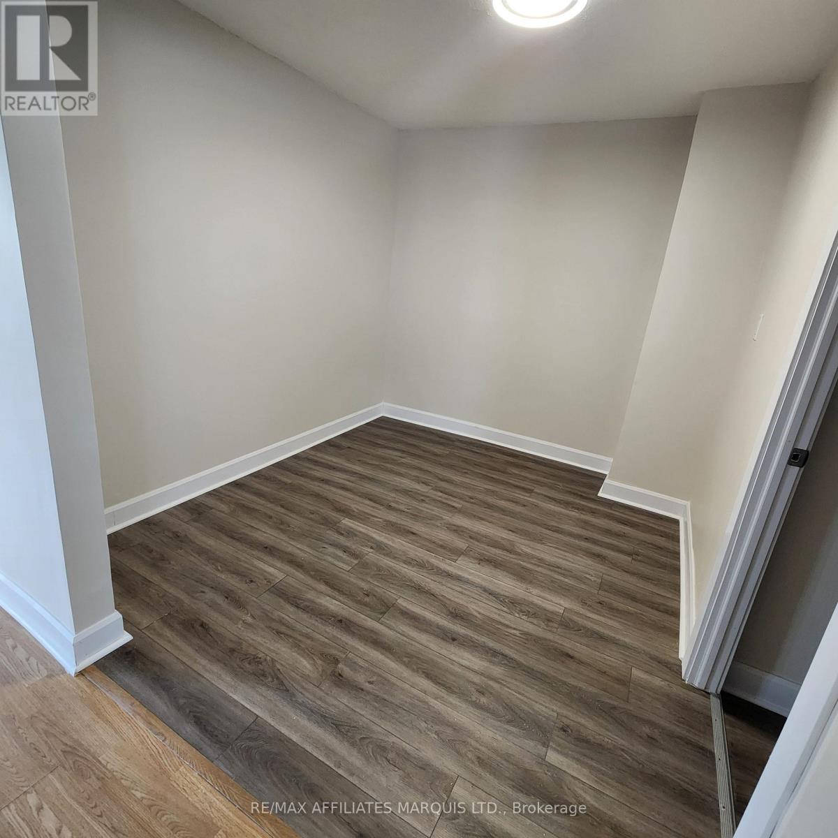A room with wooden flooring and white walls.