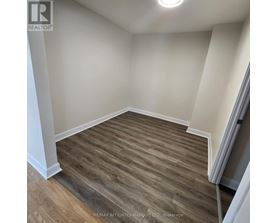 A room with wooden flooring and white walls.