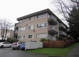 Apartment building with a white fence in front.
