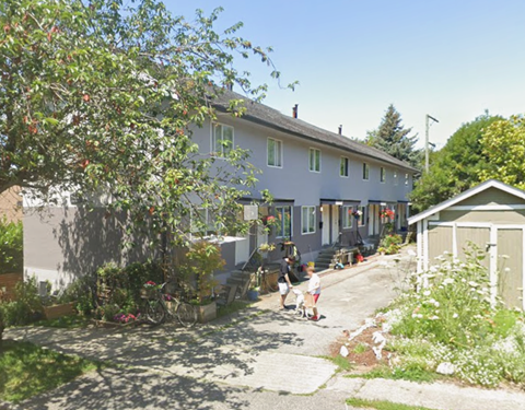 A house with a child walking in front of it.