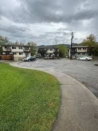 A residential area with houses and cars parked on the street.