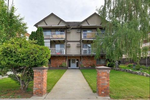 A two-story apartment building with a balcony on the second floor.