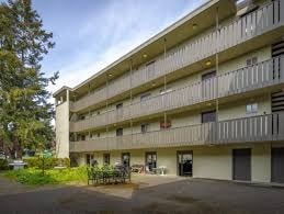 A large apartment building with a parking lot in front.