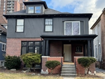 A two-story house with a black front door and white trim.