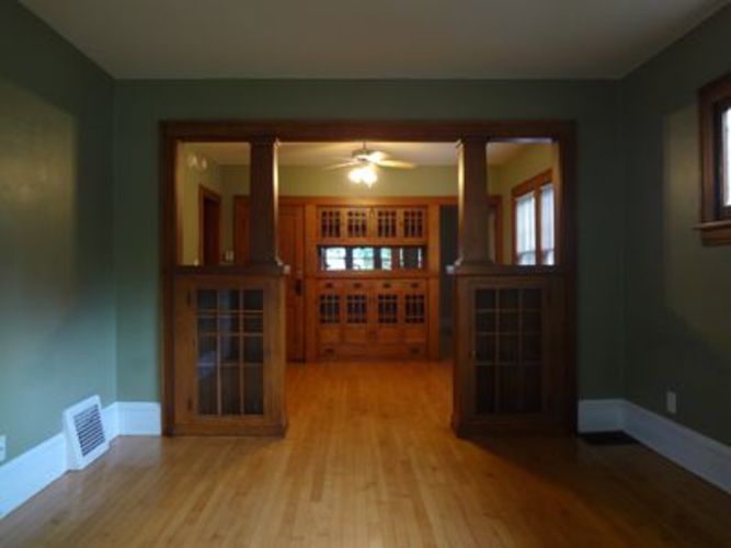 A room with a wood floor and a ceiling fan.