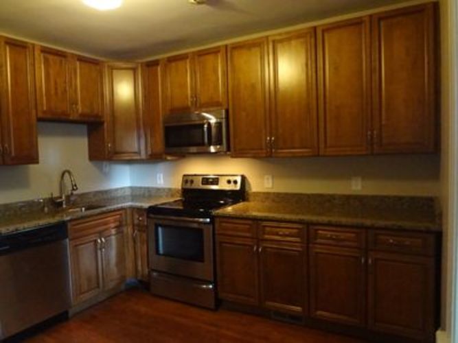A kitchen with wooden cabinets and a granite countertop.