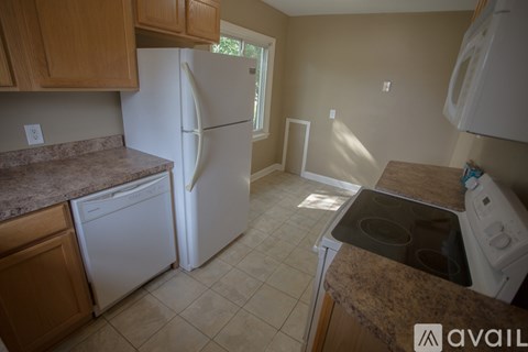 A kitchen with a white refrigerator and a granite counter top.