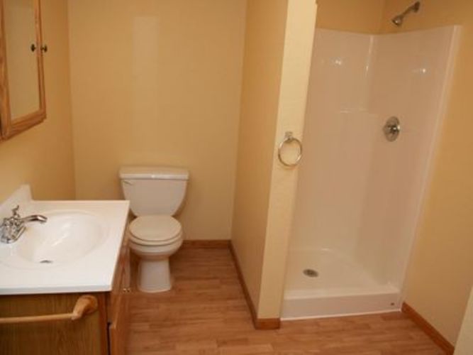 A bathroom with a toilet, sink and shower.