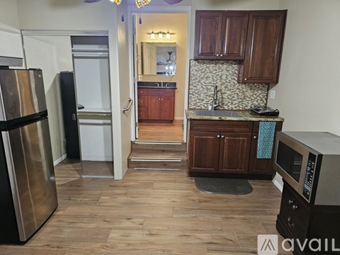 A kitchen with wooden cabinets and a refrigerator.