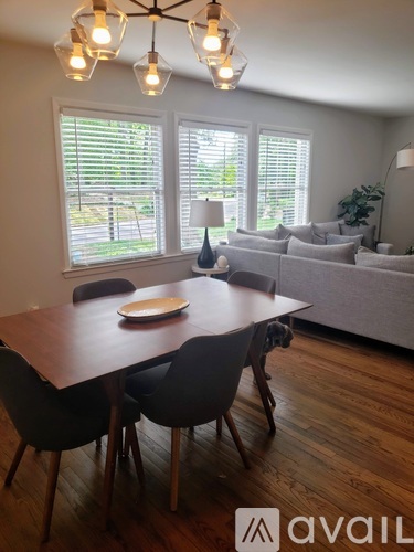 A dining room with a wooden table and chairs.