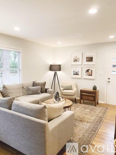 A living room with a grey couch and a white chair.