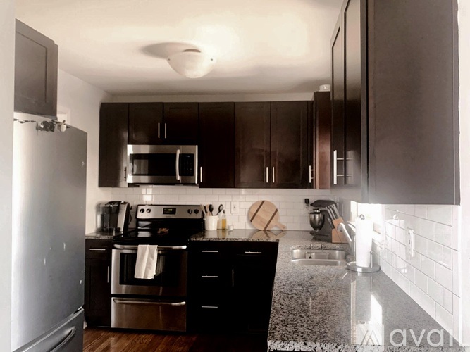 A kitchen with black cabinets and stainless steel appliances.