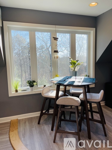 A dining room with a table and chairs.