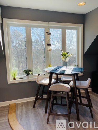 A dining room with a table and chairs.