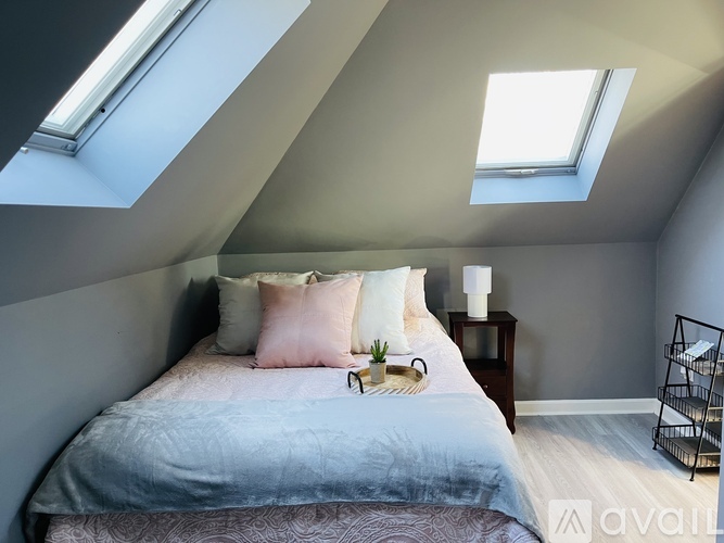 A bedroom with a bed, nightstand, and a window.