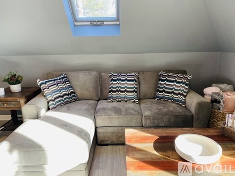 A living room with a grey couch and striped pillows.