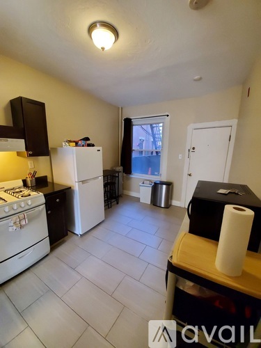 A kitchen with a white stove and black cabinets.