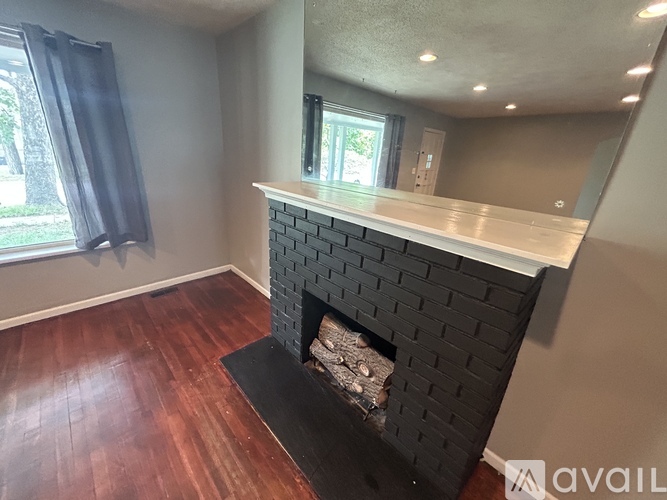 A fireplace with a black brick design and a white mantle.