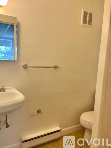 A bathroom with a toilet, sink, and shower.