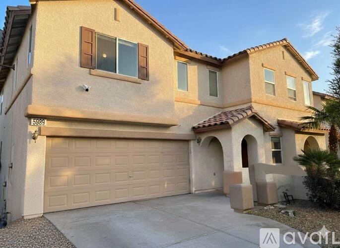 A beige house with a garage door and a window.