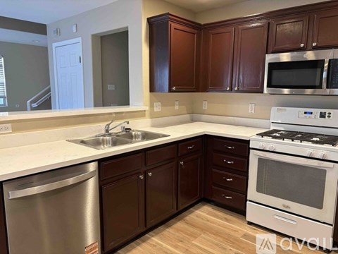 A kitchen with brown cabinets and a white countertop.