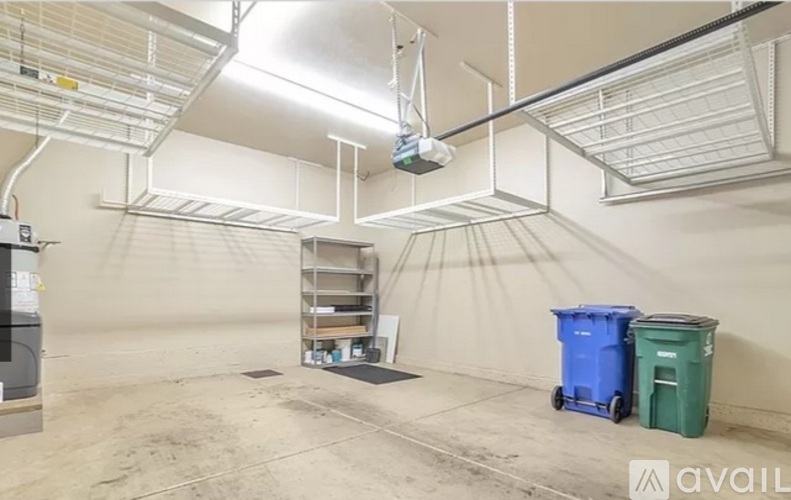 A large, empty industrial space with a blue and green bin on the floor.