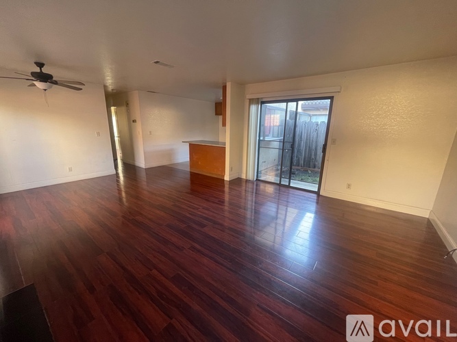 A room with wooden flooring and a ceiling fan.