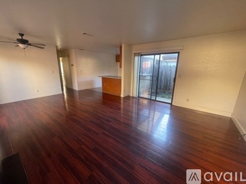 A room with wooden flooring and a ceiling fan.