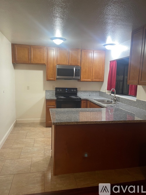 A kitchen with wooden cabinets and a granite countertop.