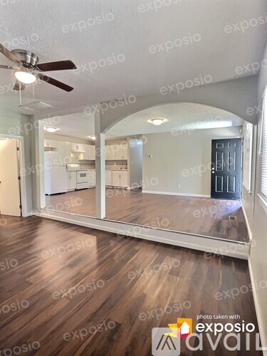 A room with wooden floors and a ceiling fan.