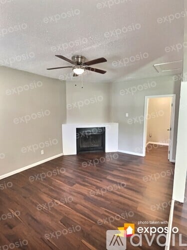 A room with a fireplace and a ceiling fan.