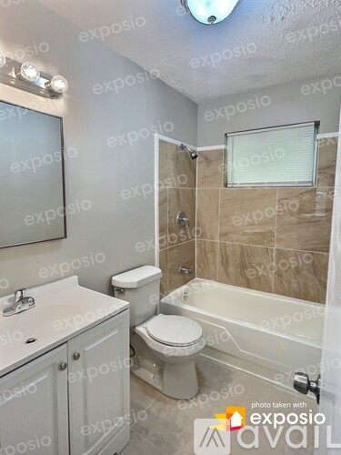 A bathroom with a toilet, sink, and bathtub.