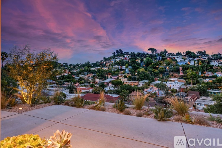 A sunset view of a residential area with houses and trees.