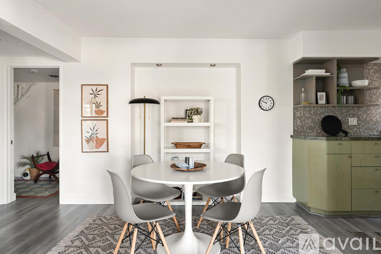 A modern dining room with a round table and chairs.