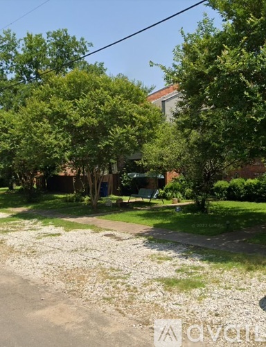 A residential area with a gravel path and greenery.
