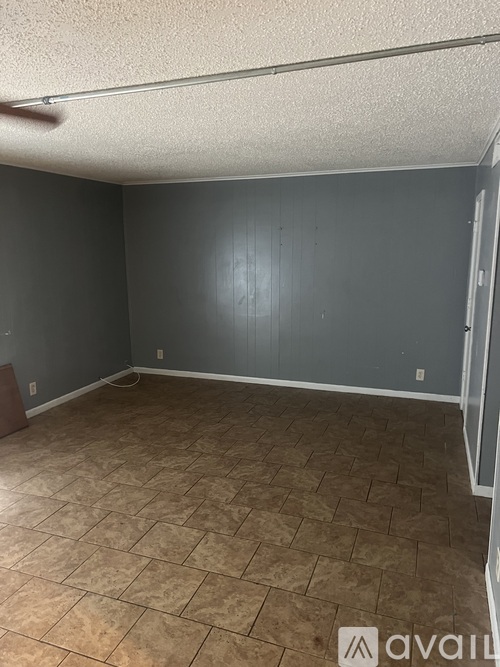 A room with a tile floor and a door on the right side.