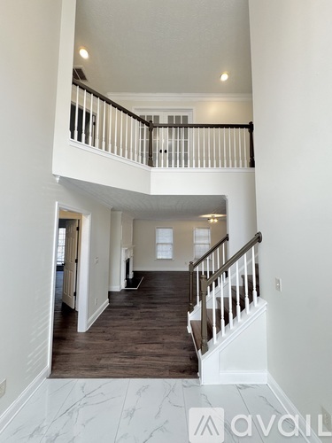 A large, empty, two-story home with a marble floor.