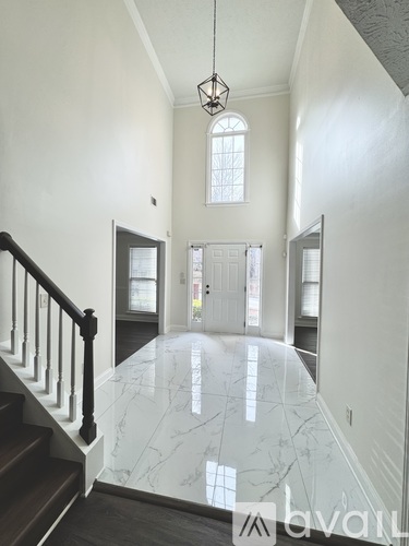 A hallway with a marble floor and a chandelier.