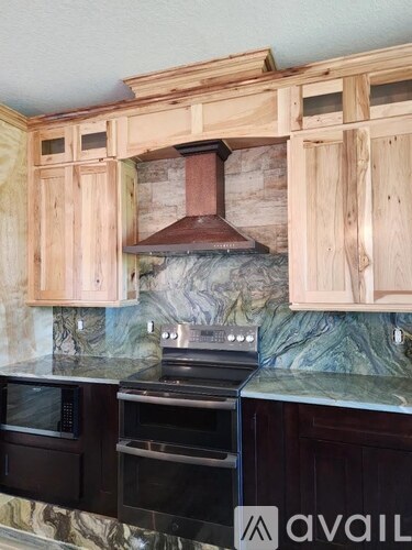 A kitchen with wooden cabinets and a marble countertop.