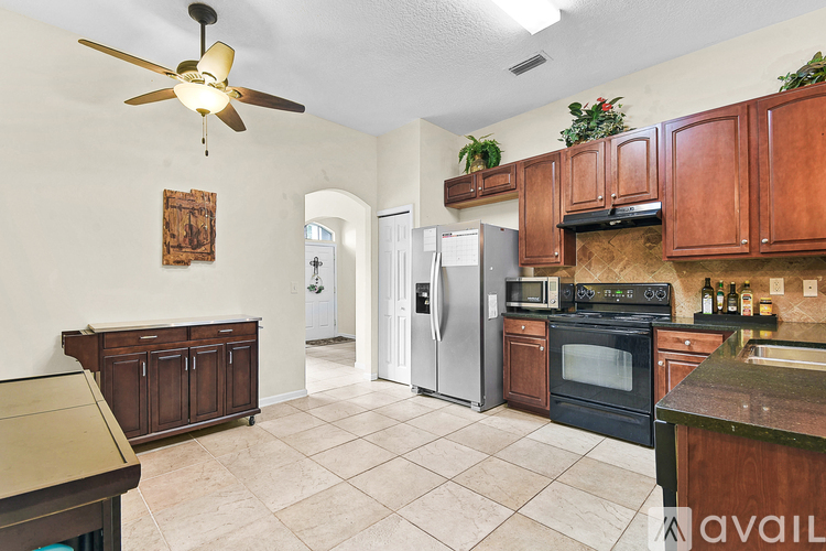 A kitchen with wooden cabinets and a tiled floor.