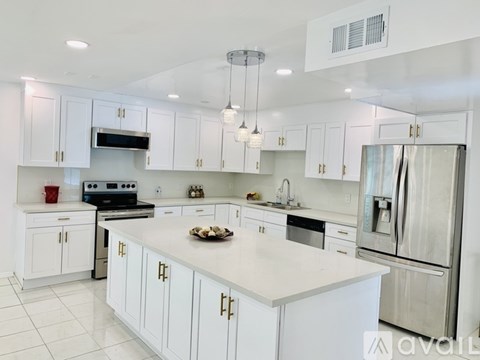 A modern kitchen with white cabinets and appliances.