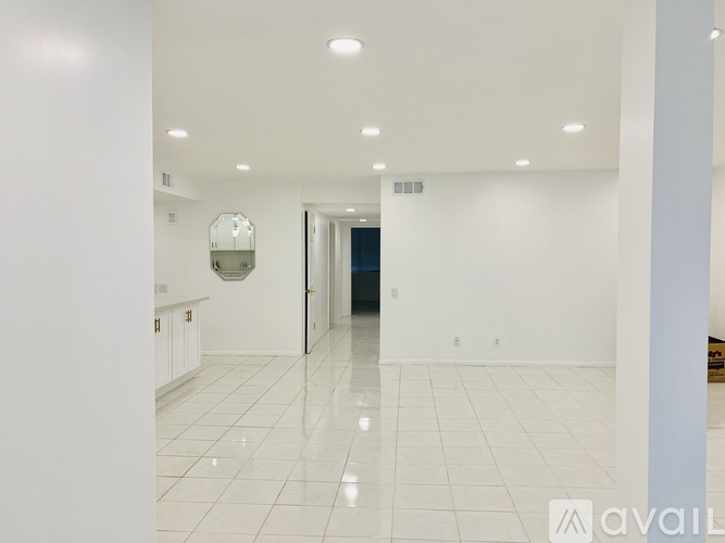 A spacious, empty room with white walls and floor.