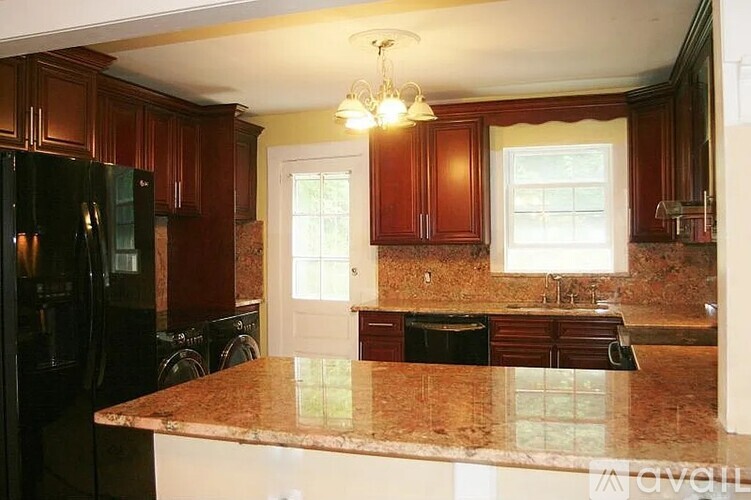 A kitchen with brown cabinets and a granite countertop.
