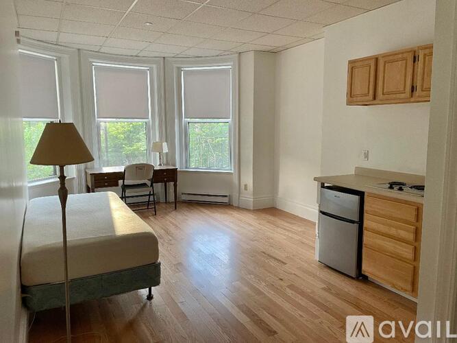 A bedroom with a bed, a chair, and a window.