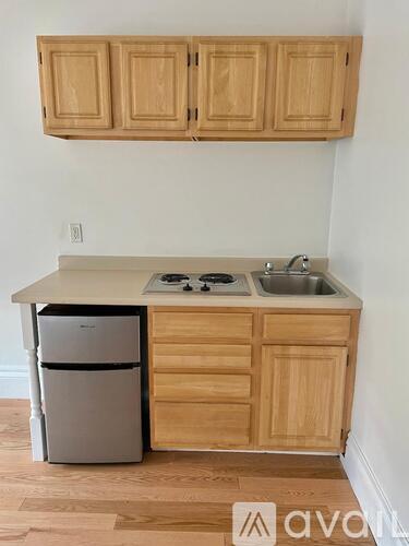 A kitchen with wooden cabinets and a white fridge.