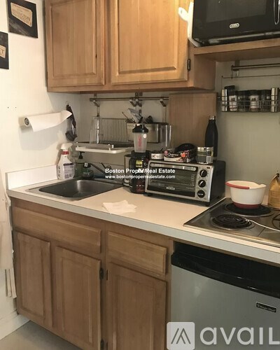 A kitchen with wooden cabinets and a stove top oven.
