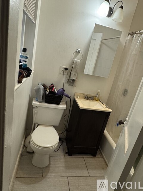 A bathroom with a toilet, sink, and mirror.